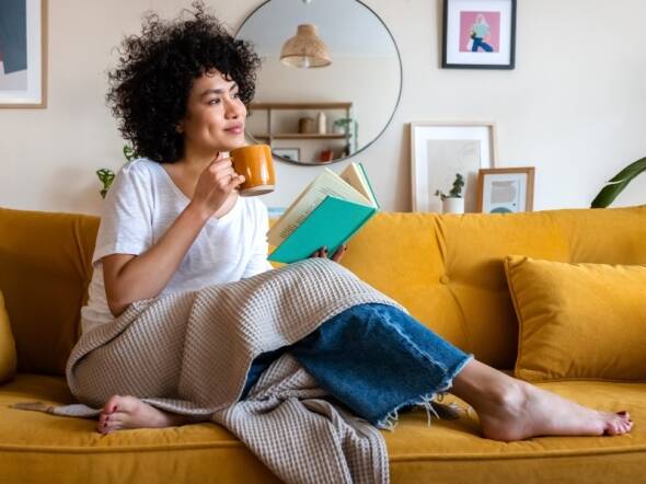 woman 35 years old sitting reading book and drinking coffee