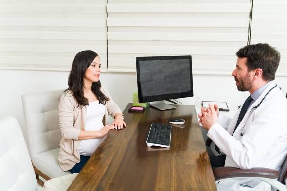 Pregnant patient talking to one of the best fertility doctors in Philadelphia